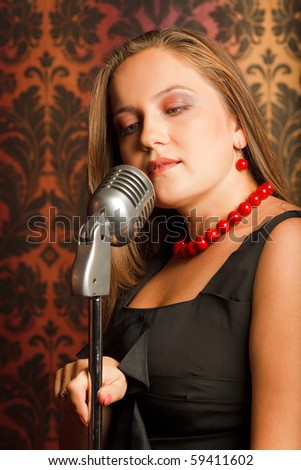 woman hugged hand vintage microphone placed on a stand. head turned to one side. ornament wallpaper