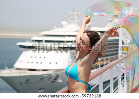 young beauty woman standing on cruise liner deck in bikini and holding pareo, half body