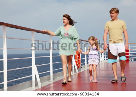 family with daughter walking on cruise liner deck, full body, looking left