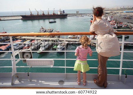 woman and her daughter standing and looking at ships in Qaboos Port.