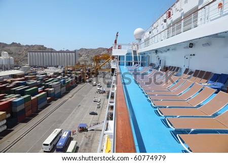 big cruise ship in port in right side of image. embarkation. many cargoes in left.