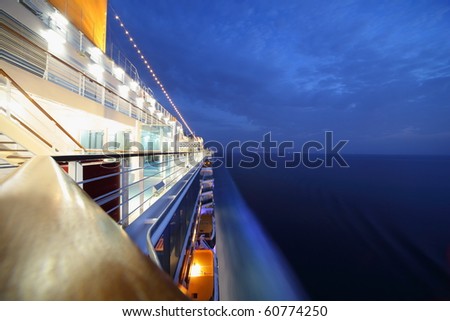 big illuminated cruise ship riding in evening. wide angle.