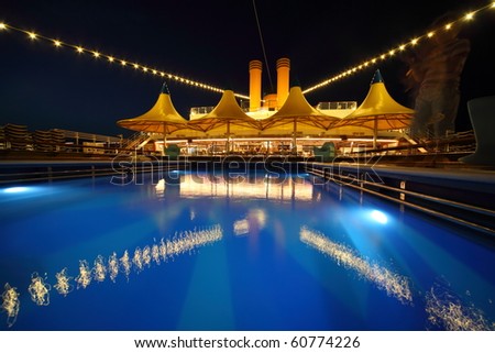 illuminated deck of ship at evening. swimming pool in deck of ship