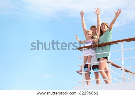 young happy family with little girl with hands up, rests on yacht and is glad at life from soul