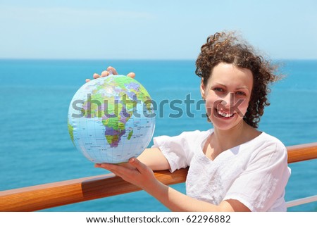 woman on deck of ship among sea with ball in form of globe
