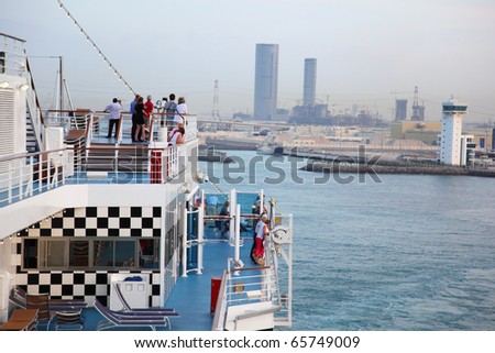 People take a rest at voyage on cruise ship at evening near city