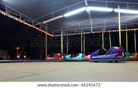 Amusement Car Ride. Several colorful, bright cars. dark night.