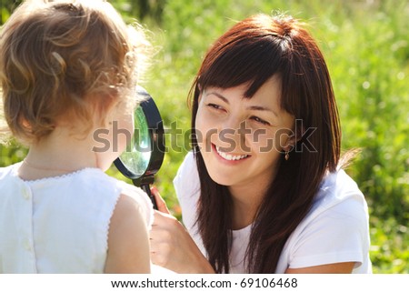 Mother and daughter looking at each other through a magnifying glass