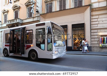 small bus goes on streets of Rome, Italy, old beautiful houses