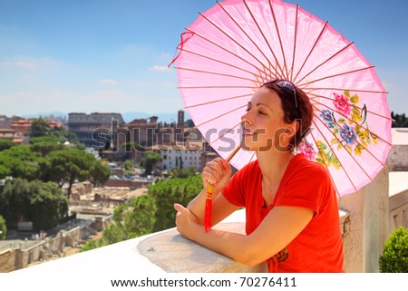 beautiful young woman with pink umbrella looks at Rome from Altar of Fatherland in Rome, Italy.