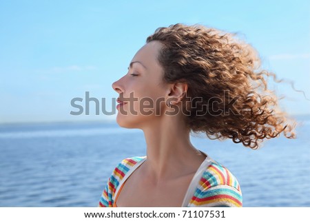 Profile of woman of which in  face blows marine wind