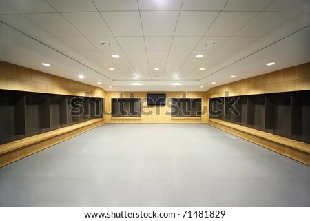 large clean locker room. gray floor and ceiling, big televisor on wall