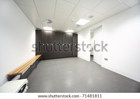 large clean locker room, gray floor and ceiling, black closet, bench near wall