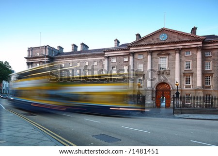 Trinity College at day in Dublin, Ireland. Bus quickly rides on road