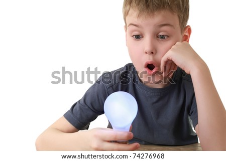 Boy holds plug in  lamp and in surprise looks at it