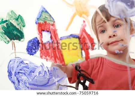 beautiful little girl in red t-shirt paints on glass, house, tree, man
