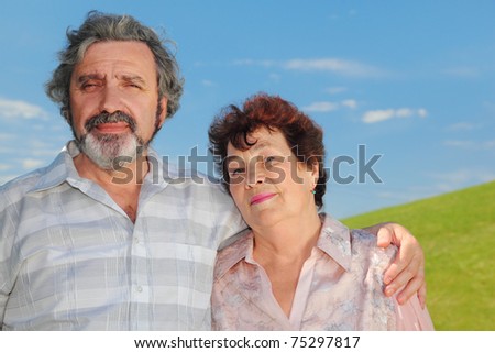 old man embracing old woman, summer lawn