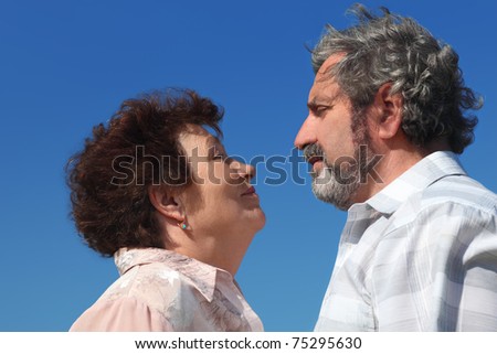 old woman and man looking to each other, blue sky