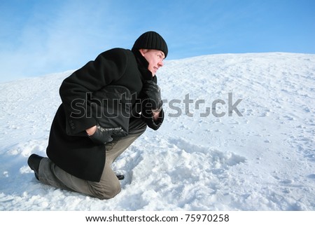 Youth leaning on one knee on snow of gravitate forward and holds brief-case in one hand