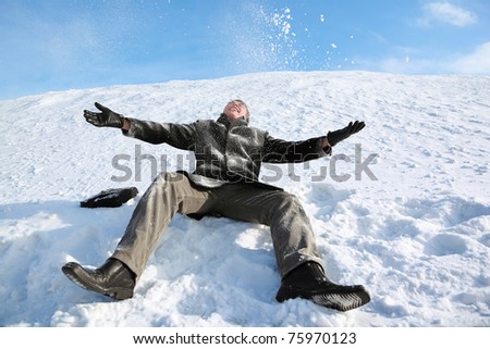 Student sits on snow by winter day and merrily throw him in sky