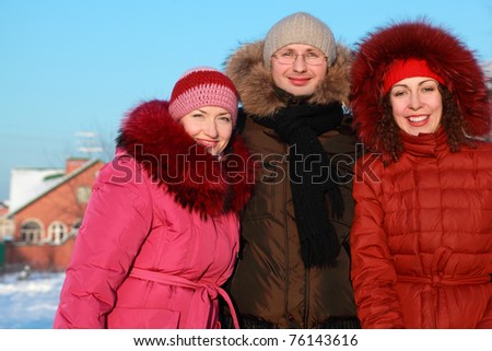 man and two women standing on outdoors in winter near to house, friends