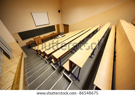 Inside university lecture hall; staircase, wooden desks and benches