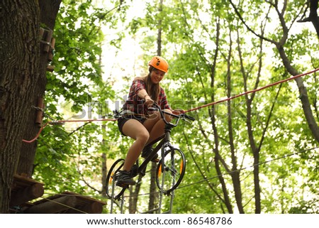 MOSCOW - SEPTEMBER 11: Girl riding bicycle on tightrope, on September 11, 2010 in Moscow, Russia. First time in Moscow rope adventure park \