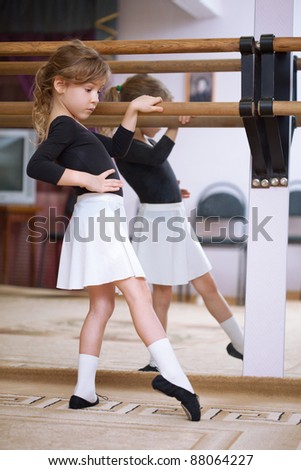 Girl at ballet barre. Ballet pas. Right profile. Reflection in mirror.