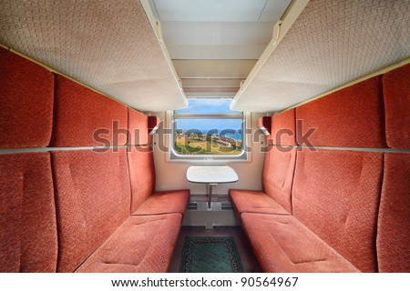 Railroad train interior. Inside of train - red seats; table and window