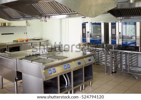 Kitchen room with stoves, sinks and refrigerators in restaurant.