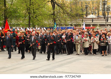 MOSCOW - MAY 8: People with flowers participate in the ceremony of wreath laying at tomb of Unknown Soldier at Victory Day celebrations, on May 8, 2011, Moscow, Russia.