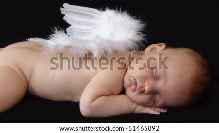 Baby boy sleeping with angel wings on his back