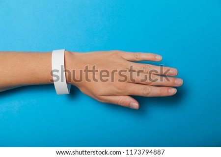 Paper wristband mockup, event bracelet on hand. Empty ticket wrist band design.