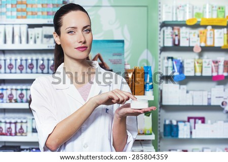 young woman in medical uniform is holding a test cream