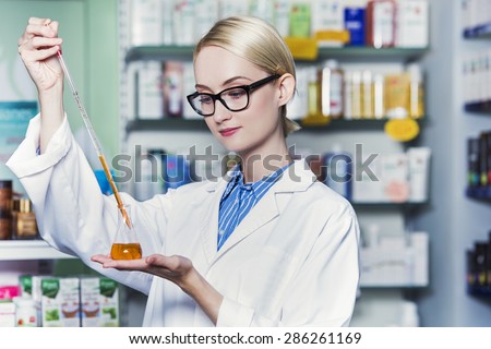woman pharmacist is holding a test tube filled with chemical ingredient