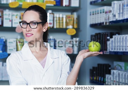 young woman doctor is holding a green apple