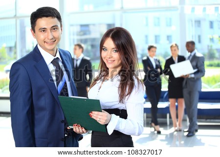 Smiling female leader discussing business plan with confident colleagues