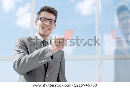 smiling employee reading a note sticker on the glass