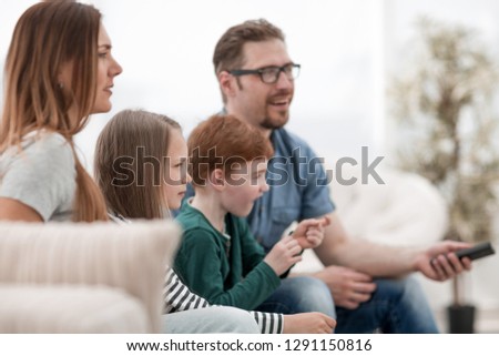 close up. the family watches their favorite show on TV