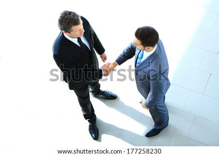 Top view of a two businessman shaking hands - Welcome to business