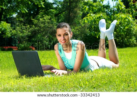 young woman on a nature with the laptop