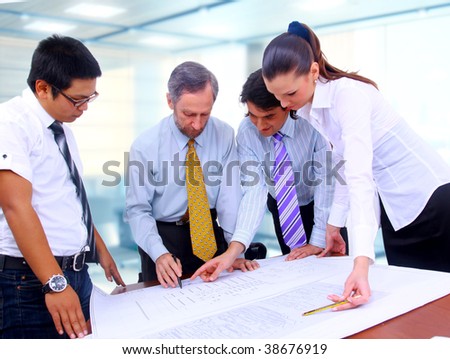 Business men and women working on blue prints