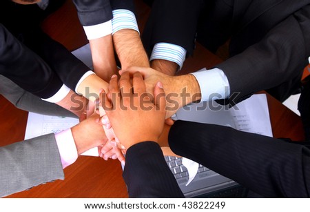 group of business people making a pile of hands in a light and modern office environment