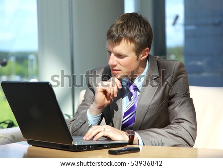 Businessman working on laptop computer at office lobby