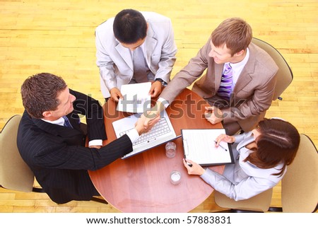 handshake over paper and pen,blurry computer in the background