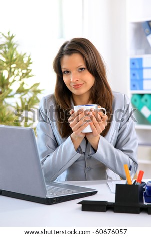 Happy young woman filling a business form while on her desk at work