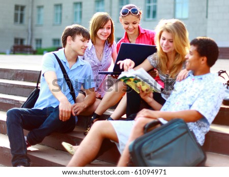 Group of five students outside sitting on steps