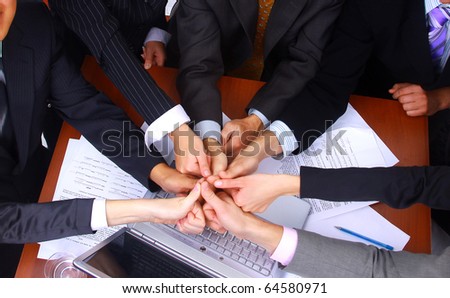 group of business people making a pile of hands in a light and modern office environment