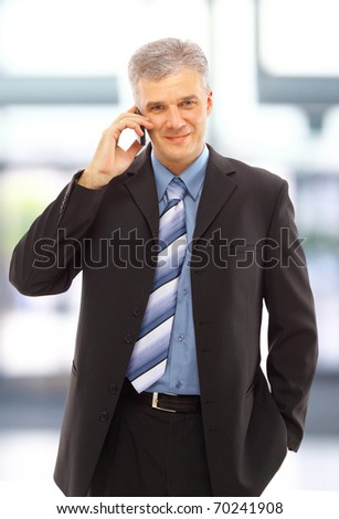 Young happy businessman calling on mobile phone, outdoor, smiling