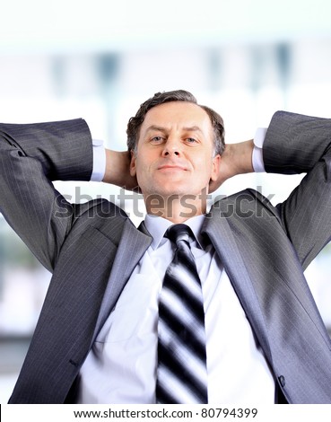 relaxed and dreaming business man sits on office chair